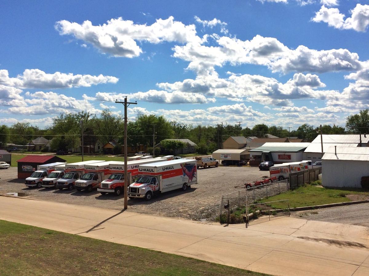 The APR (Automotive Pro Repair) lot on W Walnut Ave in Enid, with the shop building and a row of U-Haul rental trucks under a blue sky