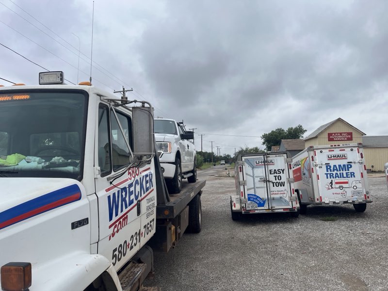 U-Haul cargo trailers parked beside the A.P.R. Automotive Service building